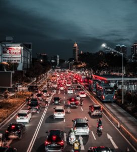 Cars and motorcycles driving on a road in the night