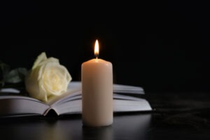 Candle sits in front of book and flower to memorialize loved one killed in wrongful death accident