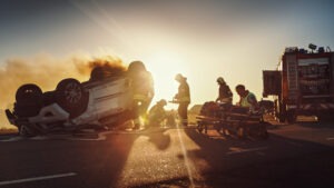 Two emergency responders rush an injured person away from the scene of an accident.