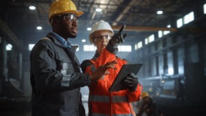 Two employees oversee a production line.