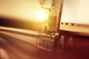 a blurred close-up image of a speeding truck on the highway