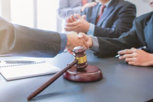 men in suits shaking hands next to a gavel