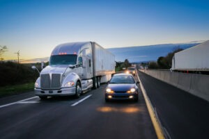 large 18-wheeler and other vehicles on a freeway at night