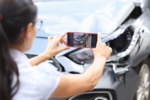 A car accident victim takes photos to send to an East Hartford car accident lawyer.