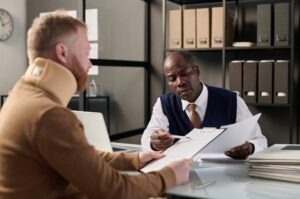 An injured man wearing a neck brace, discussing his case with a medical malpractice lawyer in Hartford, CT.