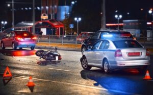 Police vehicles at a motorcycle accident scene, investigating the crash to determine fault.