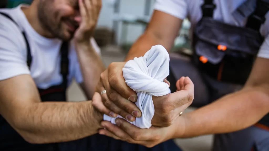 Persona recibiendo primeros auxilios en una mano lesionada