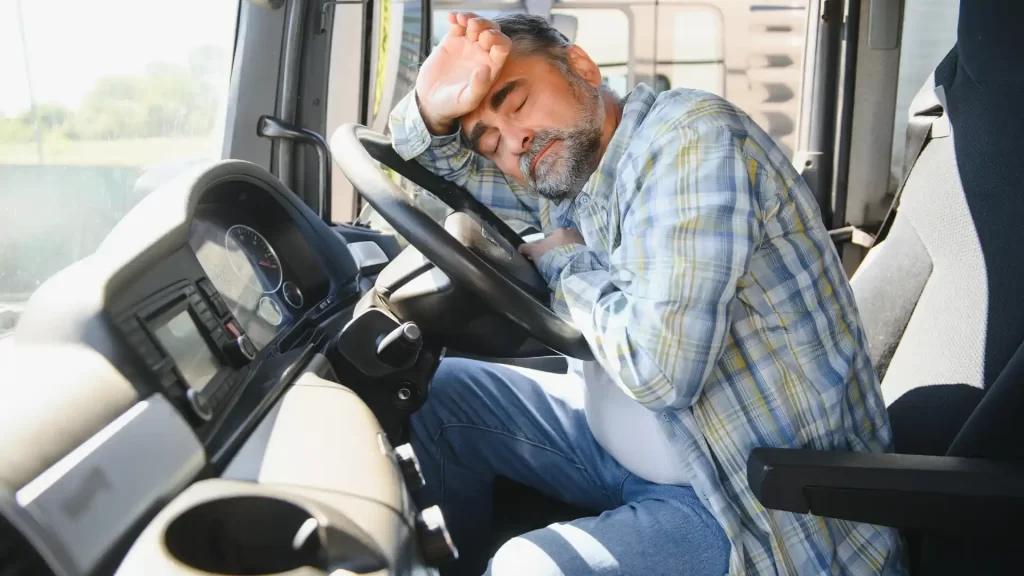 Tired driver resting at the wheel of a truck