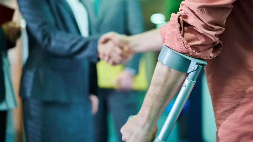 Injured person with crutch shaking hands with lawyer