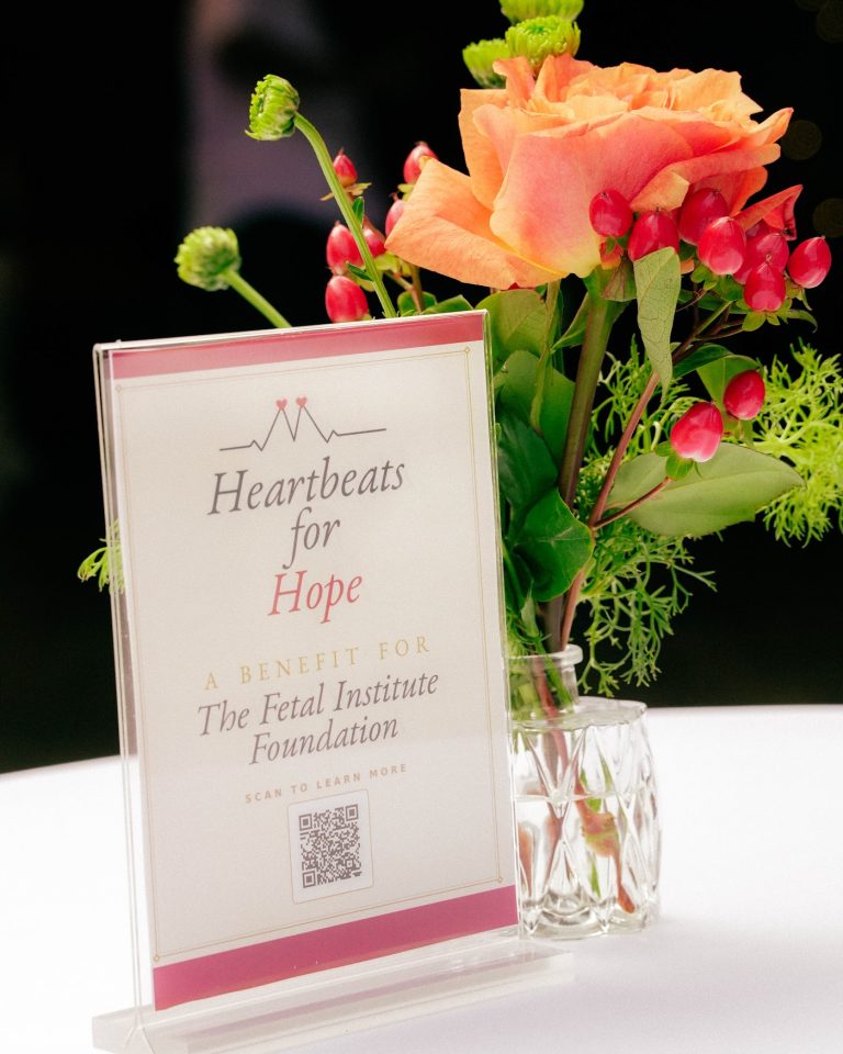 Floral centerpiece and Heartbeats for Hope signage at the evening event